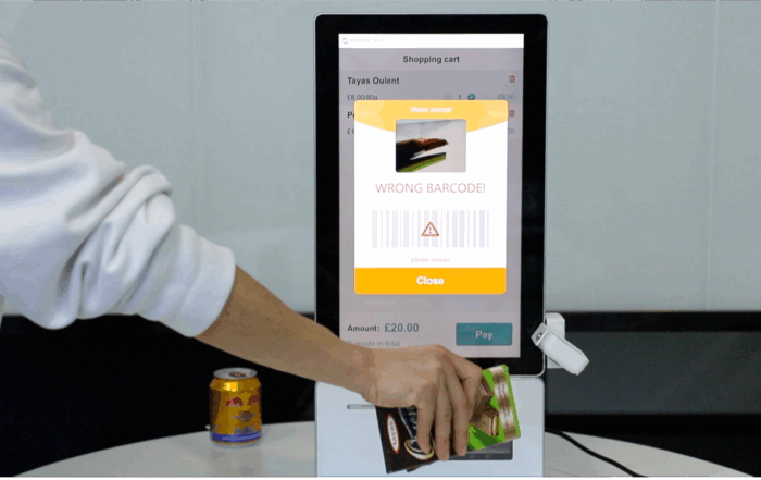 A person using a self - checkout kiosk with a "wrong barcode! " alert. It's part of solutions enhancing retail security through advanced tech like ai - driven checks.