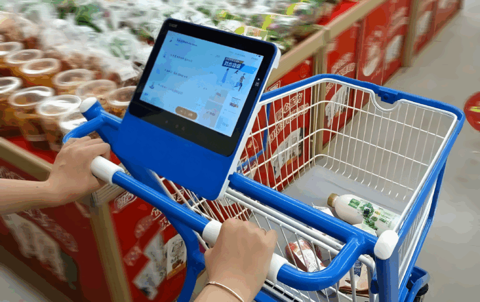 Ai - powered smart shopping cart in a supermarket, with an interactive display for member login, automatic product scanning and settlement, and delivery of personalized coupons and promotions to boost sales and customer engagement.