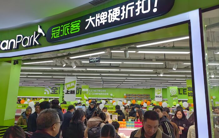 Crowded retail store with bright signage and promotions, highlighting the importance of retail loss prevention in busy shopping environments.