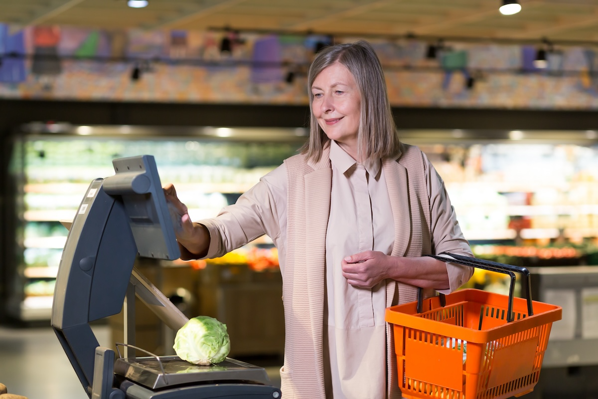A woman uses a selfservice scale equipped with ai weighing technology to weigh a cabbage showcasing how smart tech