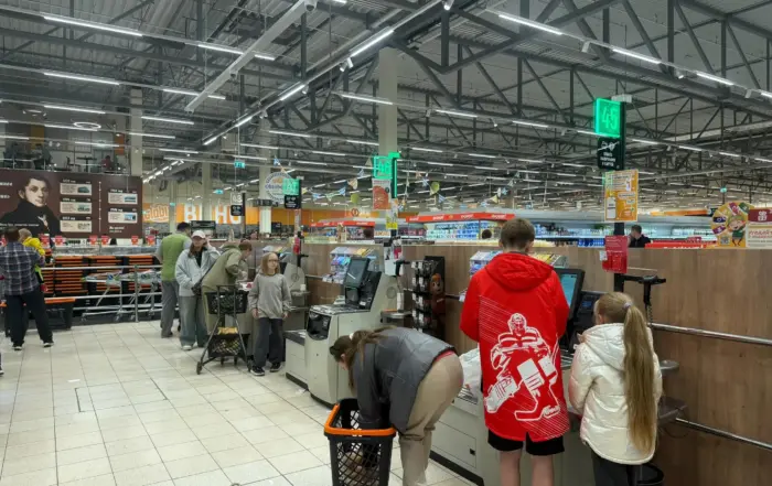 Supermarket self-checkout scene, with customers using the machines, illustrating self-checkout loss prevention in a retail environment.
