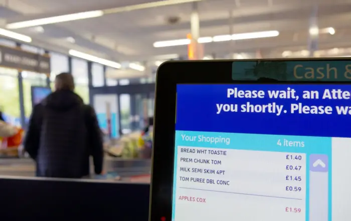 Ai checkout loss prevention solution in use at supermarket self-service till, screen displaying scanned grocery items for retail loss prevention monitoring