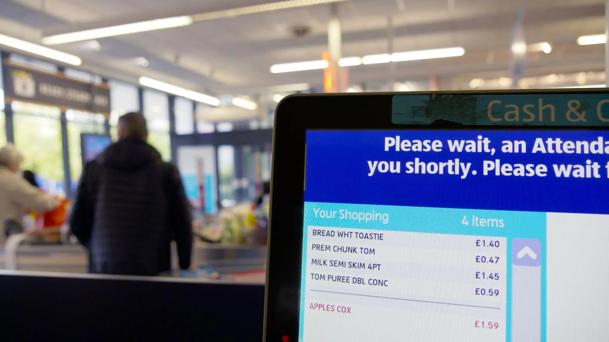 Ai checkout loss prevention solution in use at supermarket self-service till, screen displaying scanned grocery items for retail loss prevention monitoring